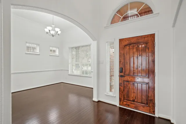 an empty room with wooden floor ceiling fan