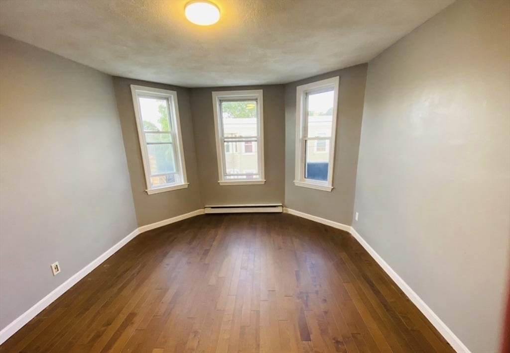 37 Maverick Street, Unit 3 Chelsea, MA 02150 - Photo 6 of 9 an empty room with wooden floor and windows