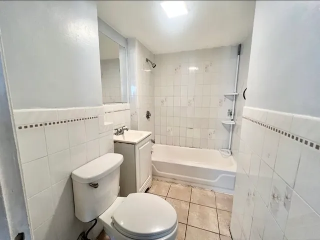 a white toilet sitting next to a bath tub and shower