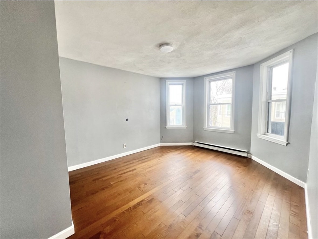 37 Maverick Street, Unit 3 Chelsea, MA 02150 - Photo 9 of 9 an empty room with wooden floor and windows