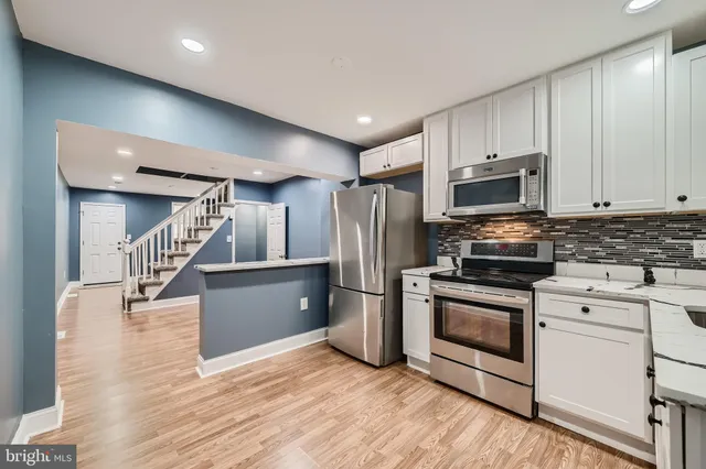 a kitchen with stainless steel appliances kitchen island granite countertop a stove a refrigerator and a microwave