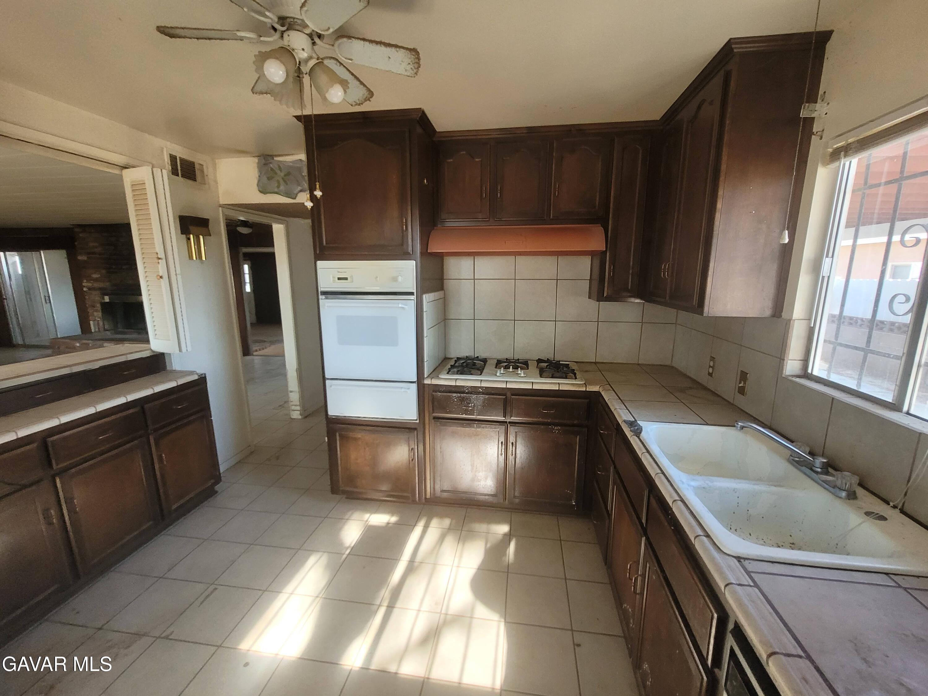 13420 Gilbert Street North Edwards, CA 93523 - Photo 12 of 20 a kitchen with stainless steel appliances granite countertop a sink stove and refrigerator