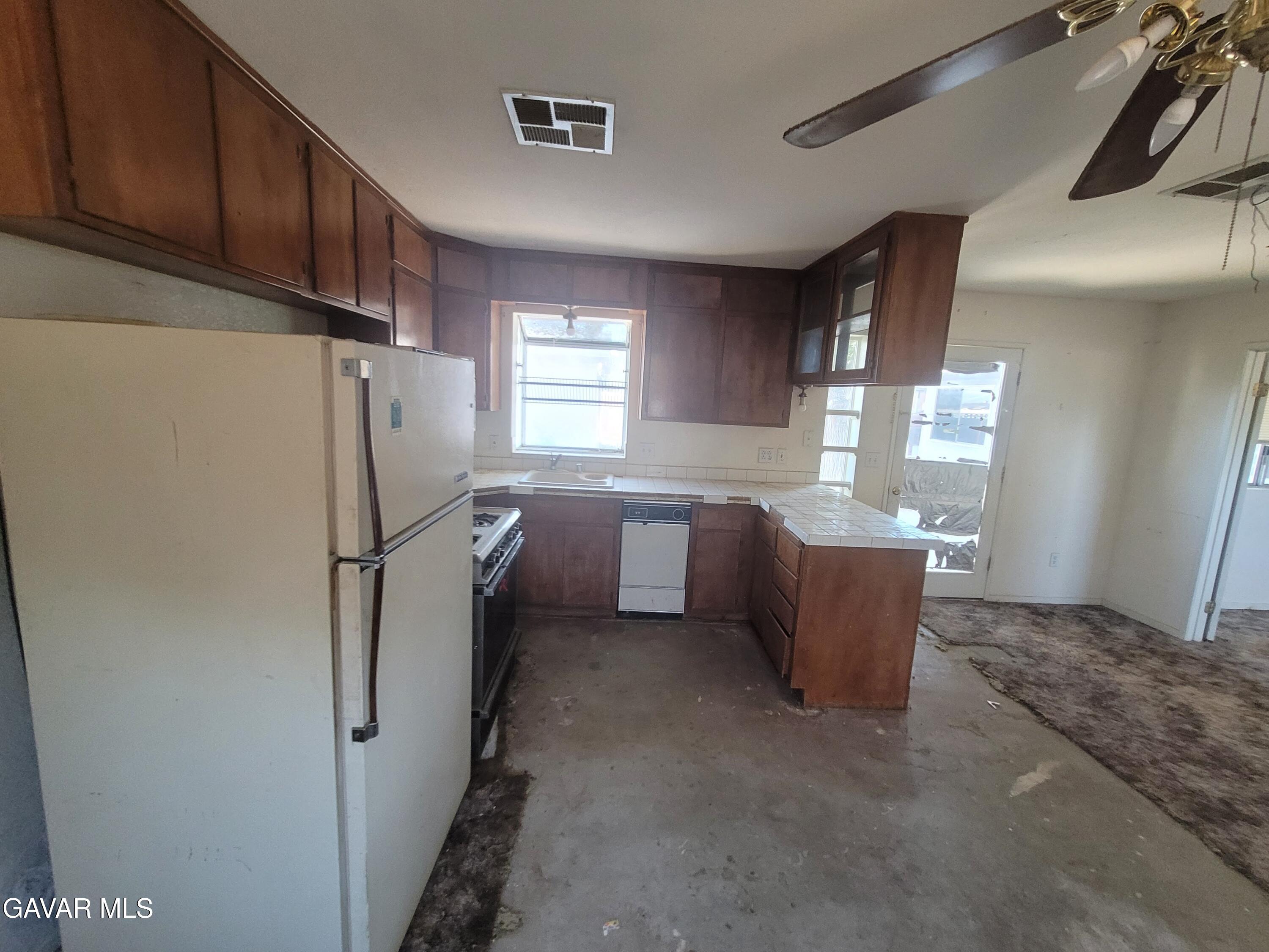 13420 Gilbert Street North Edwards, CA 93523 - Photo 9 of 20 a kitchen with a refrigerator and window