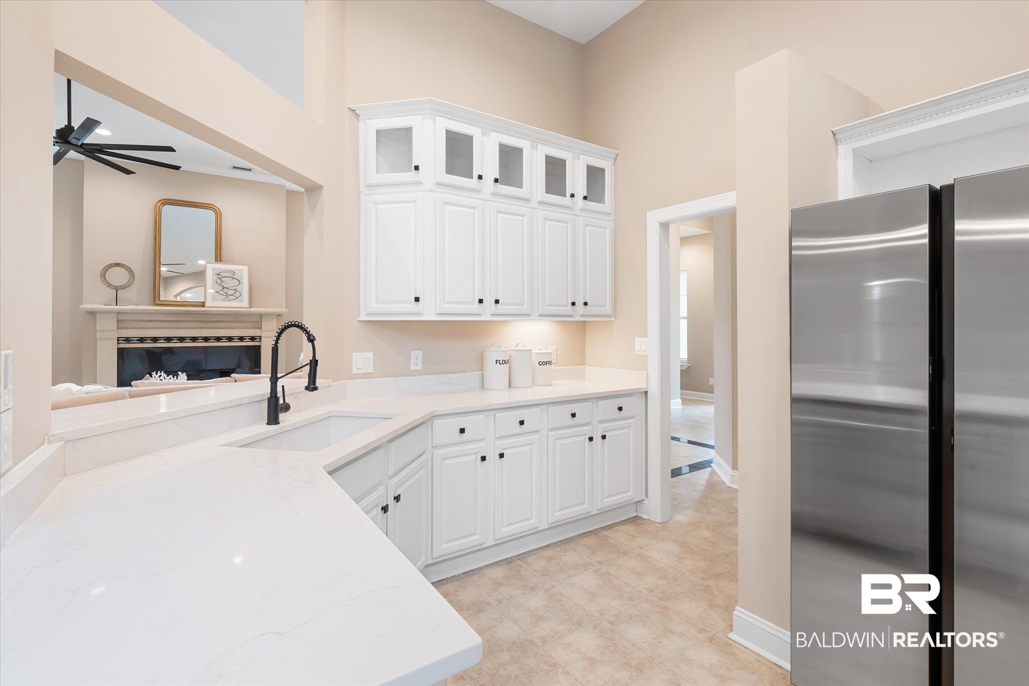 9259 Genipa Way Gulf Shores, AL 36542 - Photo 18 of 72 Kitchen featuring sink, white cabinets, stainless steel fridge, ceiling fan, and light stone countertops
