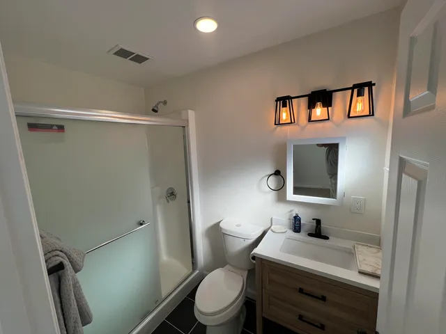a bathroom with a toilet a sink and shower
