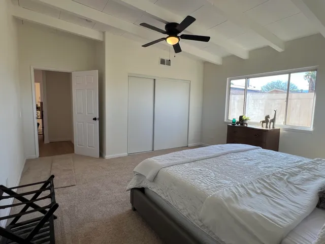 a bedroom with a bed and a large window