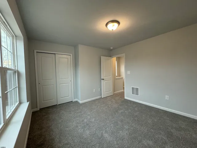 an empty room with windows and cabinet