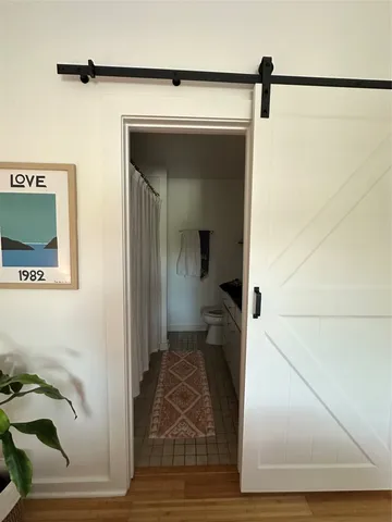 a view of a hallway with wooden floor and a cabinet