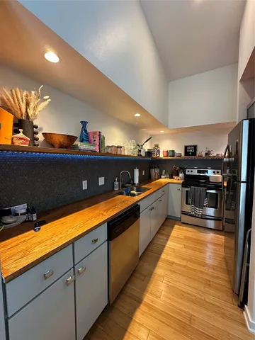 a large kitchen with stainless steel appliances kitchen island granite countertop a sink and cabinets