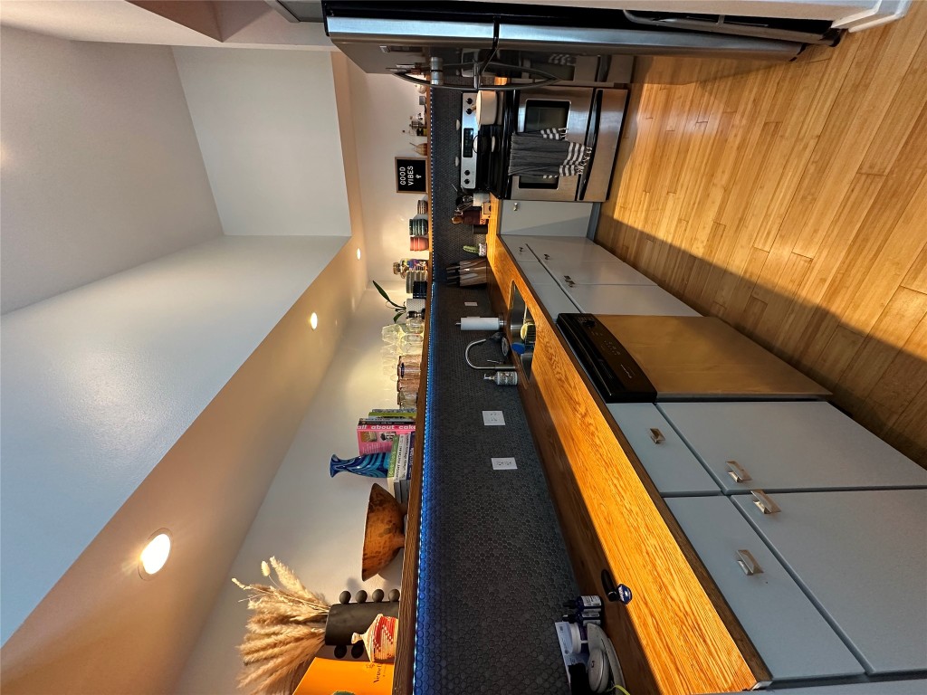 2200 Dickson Drive, Unit 216 Austin, TX 78704 - Photo 8 of 10 a large kitchen with stainless steel appliances kitchen island granite countertop a sink and cabinets