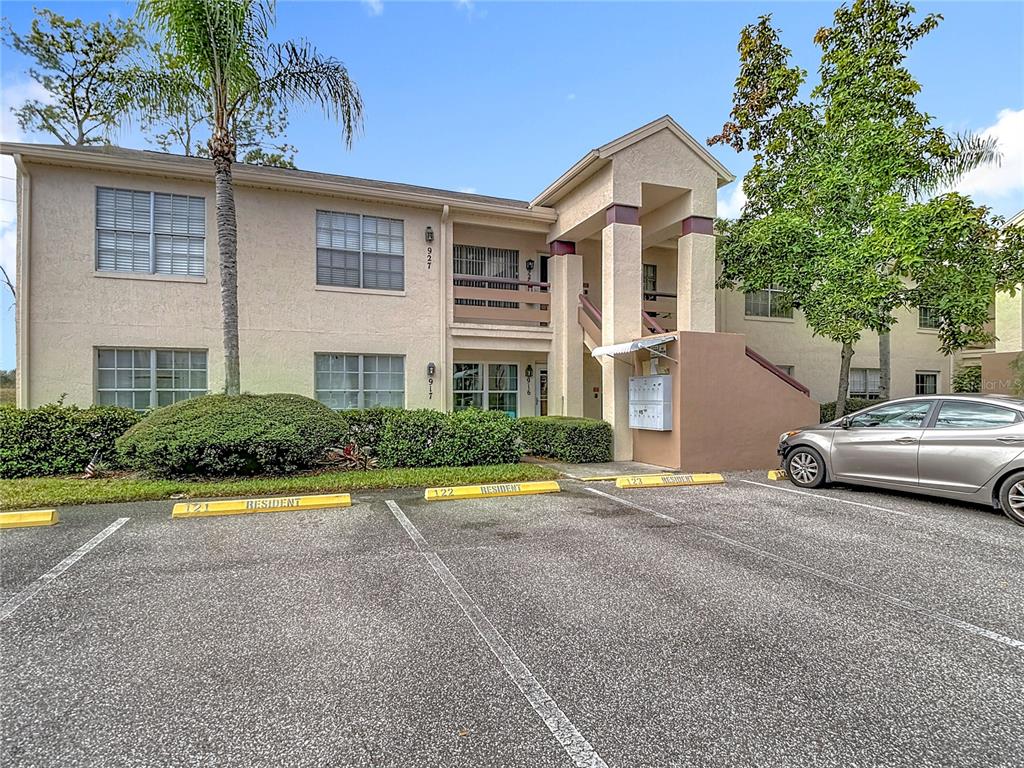 a front view of a house with a garden and trees