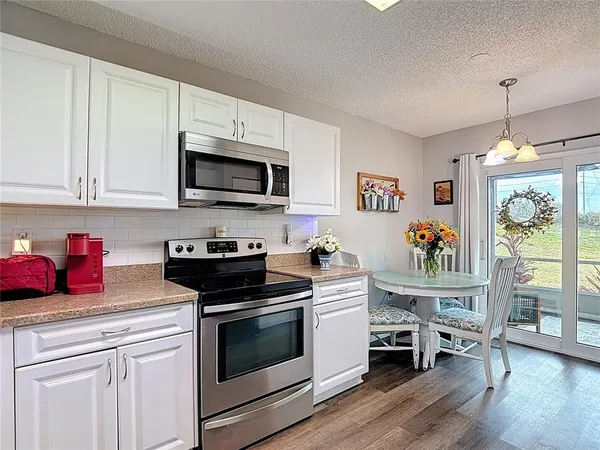 a kitchen with white cabinets and white appliances