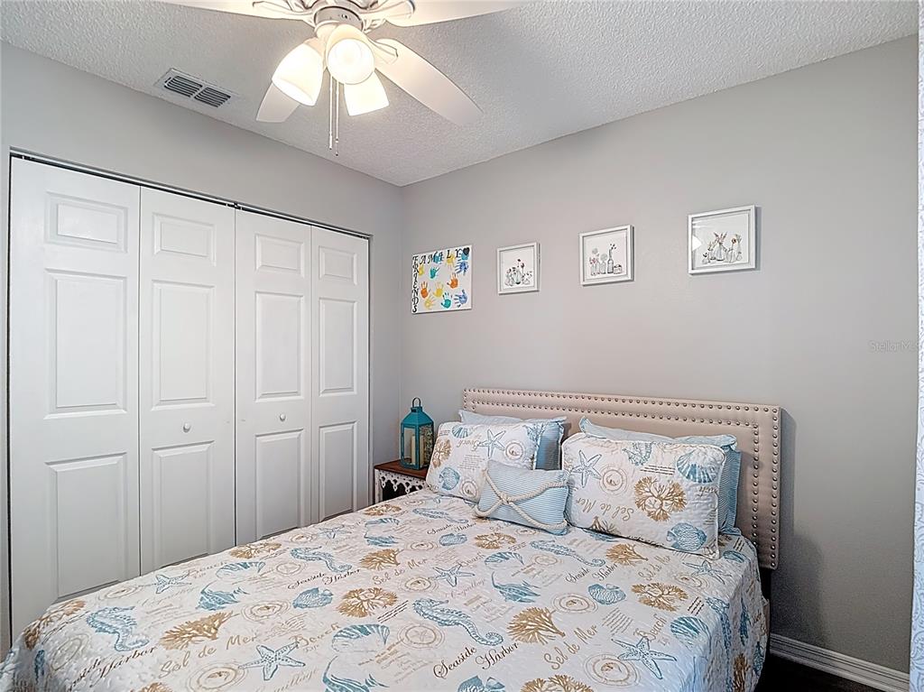 7828 Hardwick Drive, Unit 916 New Port Richey, FL 34653 - Photo 21 of 40 a bedroom with a bed and a chandelier