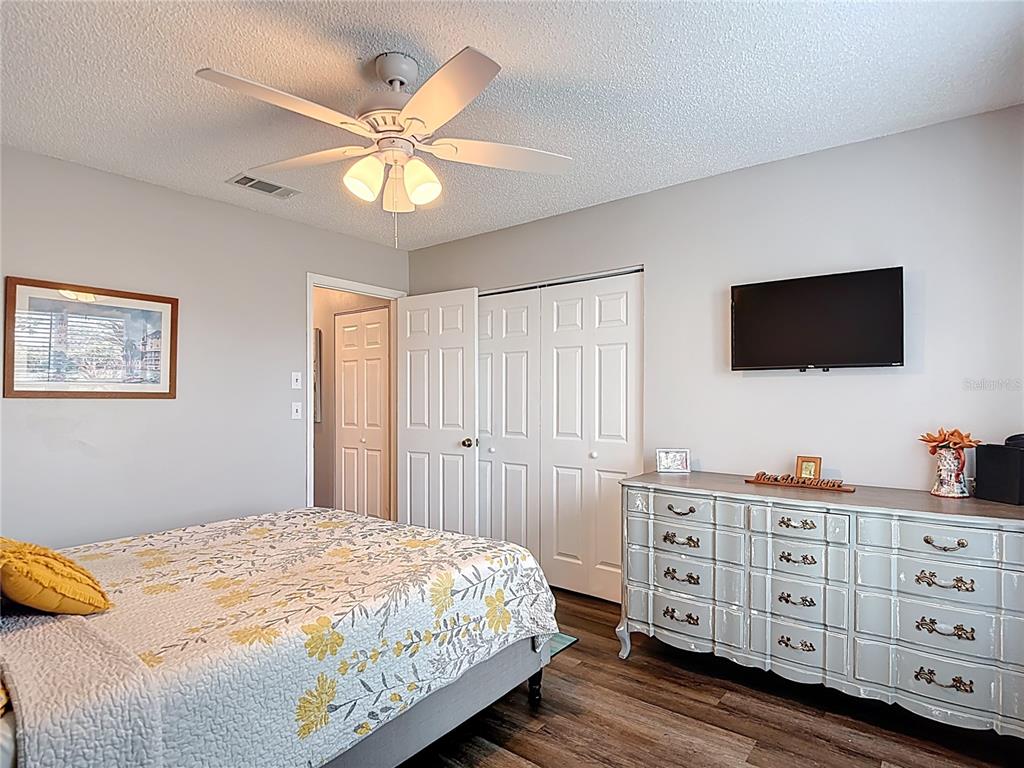 7828 Hardwick Drive, Unit 916 New Port Richey, FL 34653 - Photo 26 of 40 a bedroom with a bed and a flat tv screen on dresser