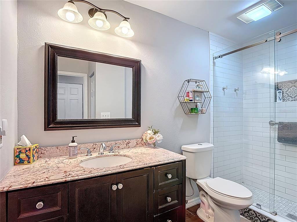 7828 Hardwick Drive, Unit 916 New Port Richey, FL 34653 - Photo 27 of 40 a bathroom with a granite countertop toilet sink and mirror