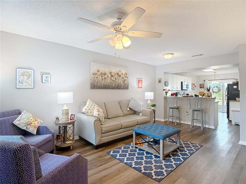 7828 Hardwick Drive, Unit 916 New Port Richey, FL 34653 - Photo 3 of 40 a living room with furniture a chandelier and a rug