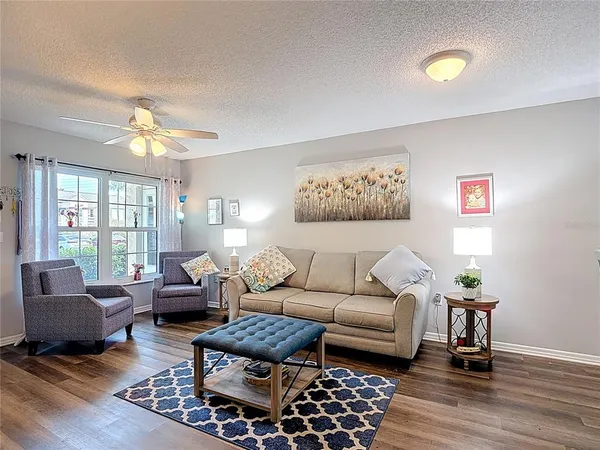 a living room with furniture a flat screen tv and a floor to ceiling window