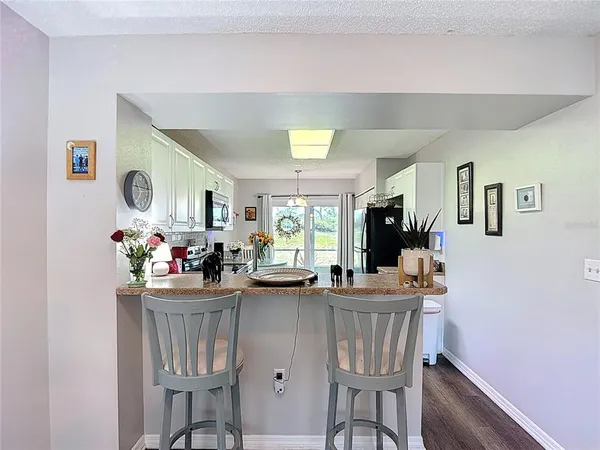 a kitchen with a table chairs refrigerator and microwave