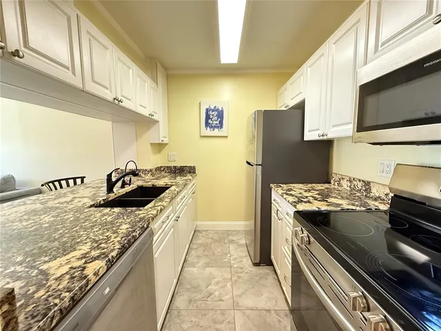a kitchen with stainless steel appliances granite countertop a stove a sink and a refrigerator