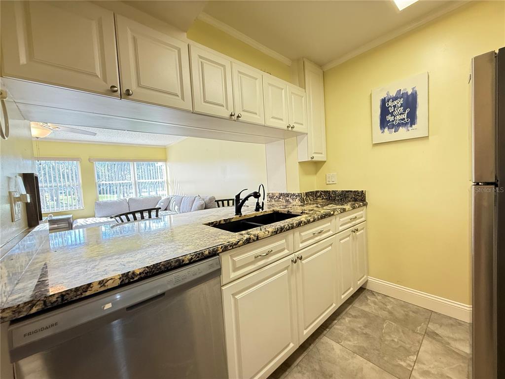 12200 Vonn Road, Unit 2105 Largo, FL 33774 - Photo 21 of 37 a kitchen with stainless steel appliances granite countertop a sink stove and cabinets