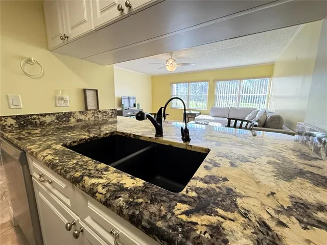 a kitchen with granite countertop a stove and a sink