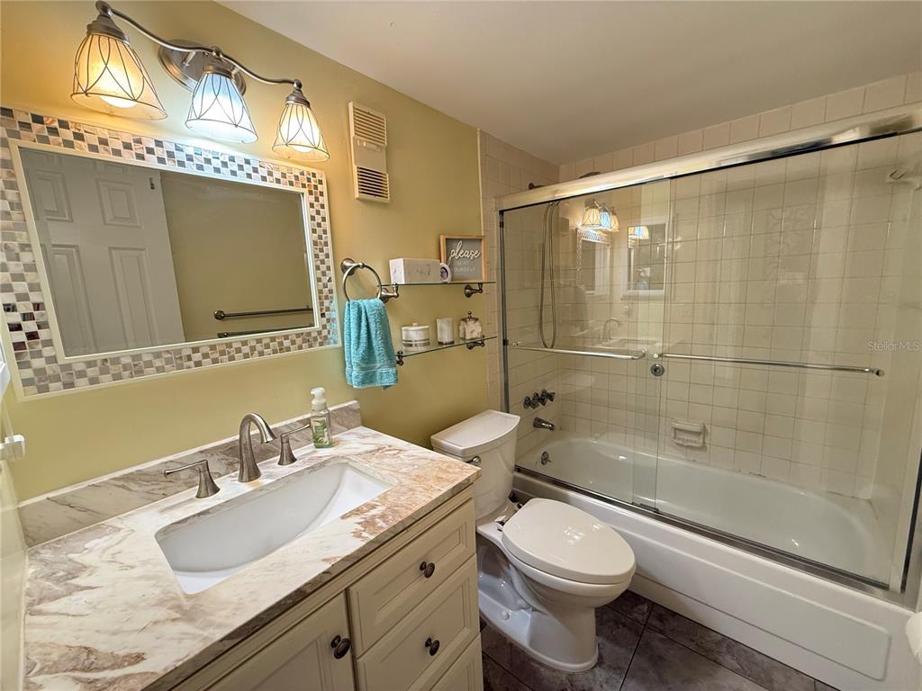 12200 Vonn Road, Unit 2105 Largo, FL 33774 - Photo 29 of 37 a bathroom with a granite countertop sink toilet and shower