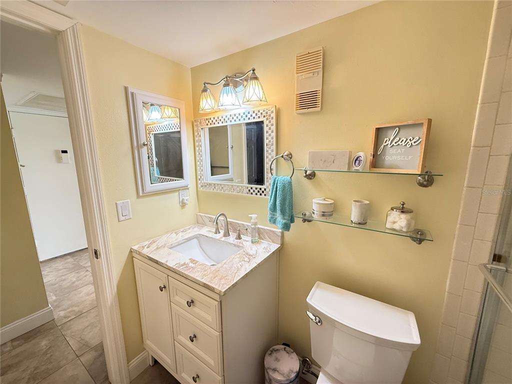 12200 Vonn Road, Unit 2105 Largo, FL 33774 - Photo 30 of 37 a bathroom with a granite countertop toilet sink and mirror