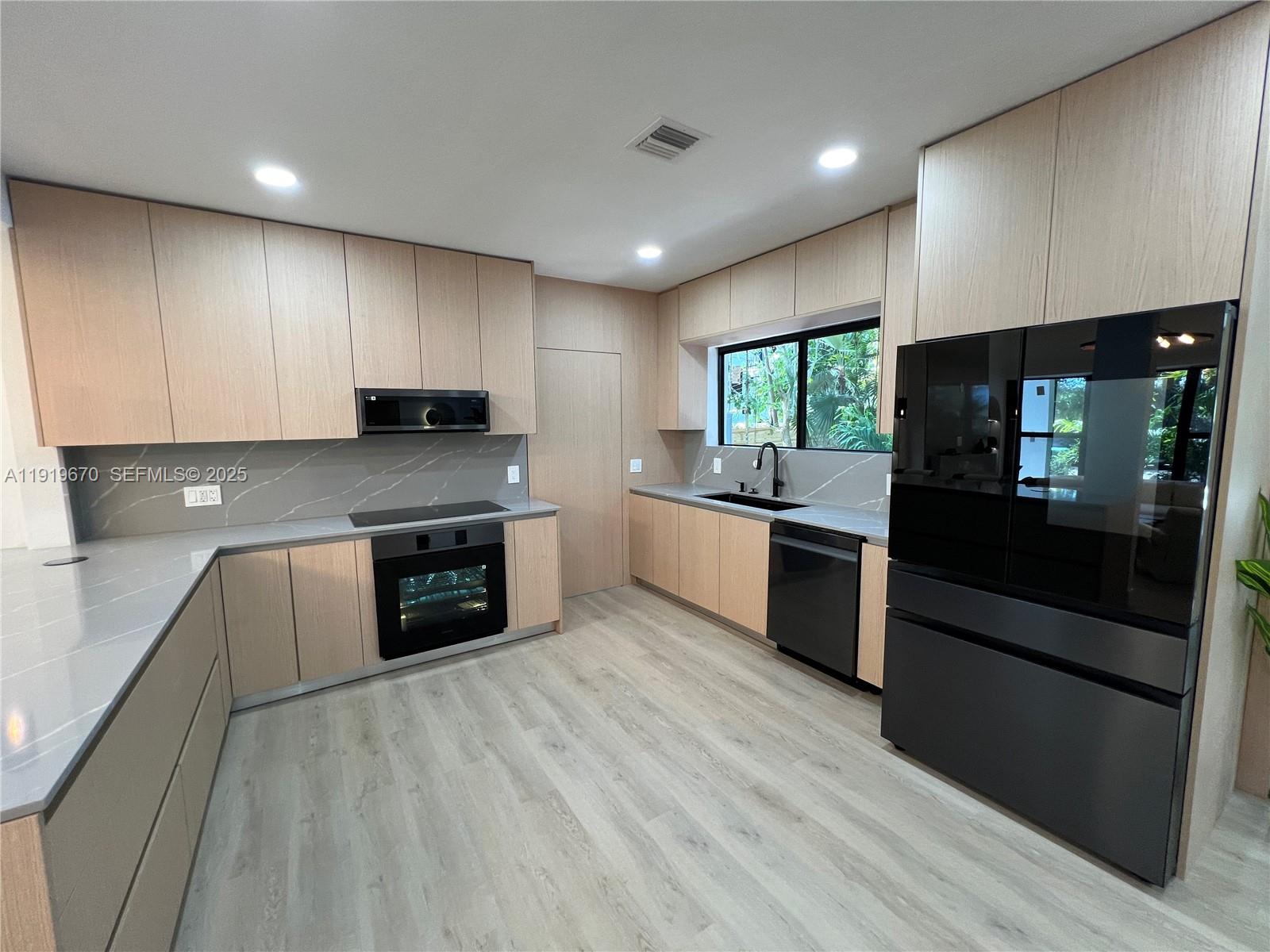 751 Northeast 80th Street Miami, FL 33138 - Photo 11 of 32 a large kitchen with stainless steel appliances granite countertop a stove a sink and a microwave