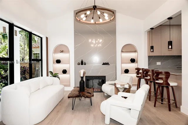 a living room with furniture a fireplace and a large window