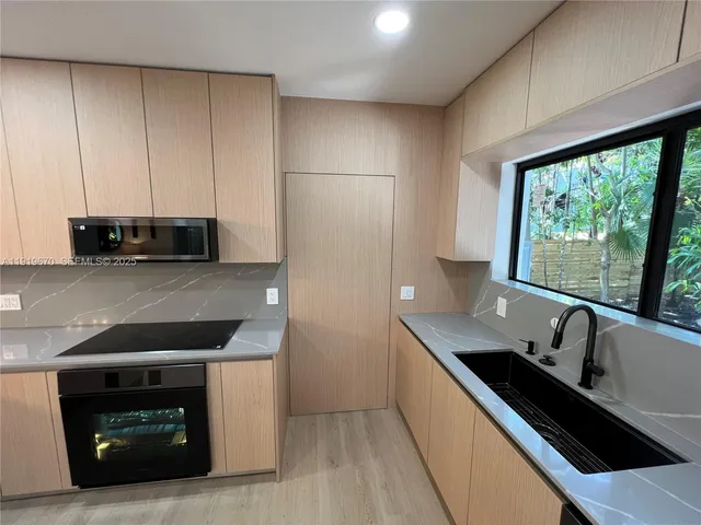a kitchen with stainless steel appliances a sink stove and cabinets