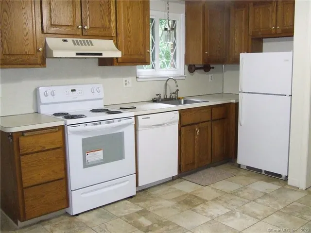 a kitchen with a stove sink and cabinets