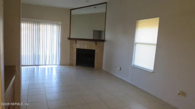 an empty room with windows and fireplace