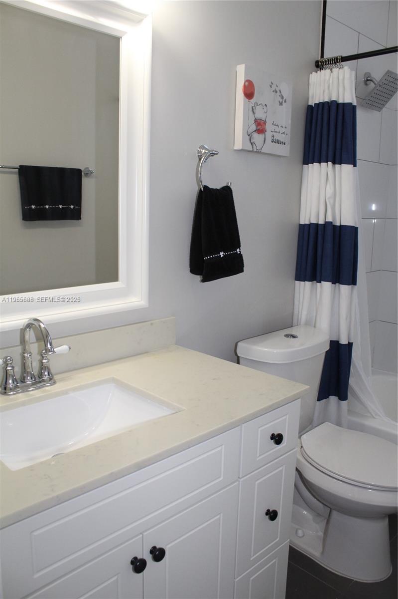 20135 Southwest 129th Avenue Miami, FL 33177 - Photo 29 of 54 a bathroom with a sink a toilet and a mirror
