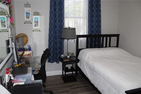 a view of a kitchen with refrigerator and wooden floor