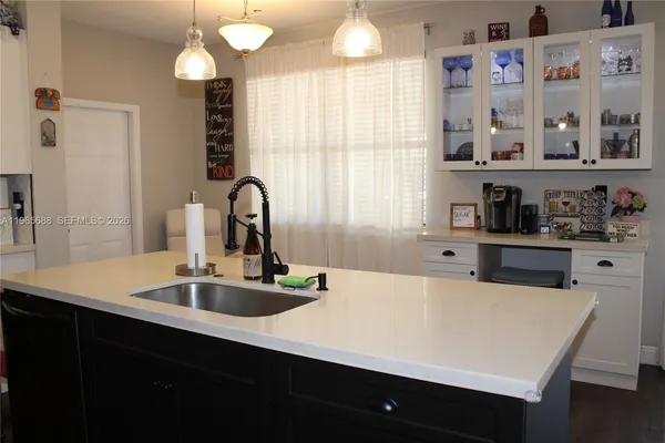 a kitchen with stainless steel appliances granite countertop a refrigerator a stove and a sink with wooden floor