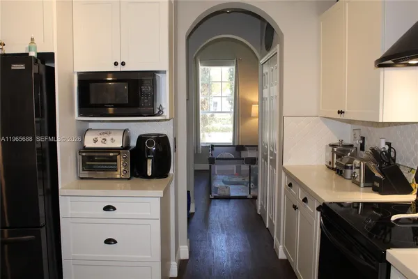 a kitchen with stainless steel appliances a sink a stove a refrigerator and wooden floor