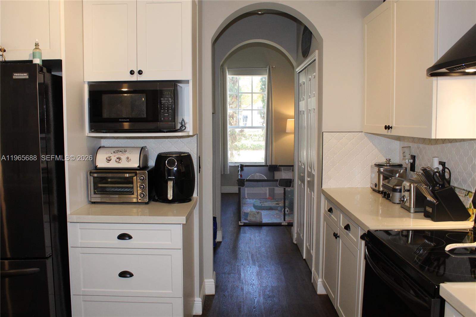 20135 Southwest 129th Avenue Miami, FL 33177 - Photo 39 of 54 a kitchen with stainless steel appliances a stove cabinets and a wooden floor