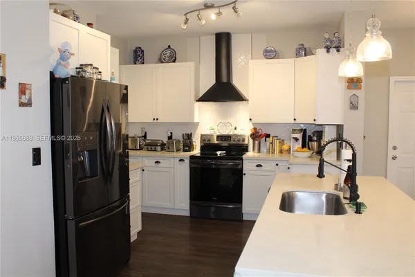 a kitchen with a refrigerator and white cabinets