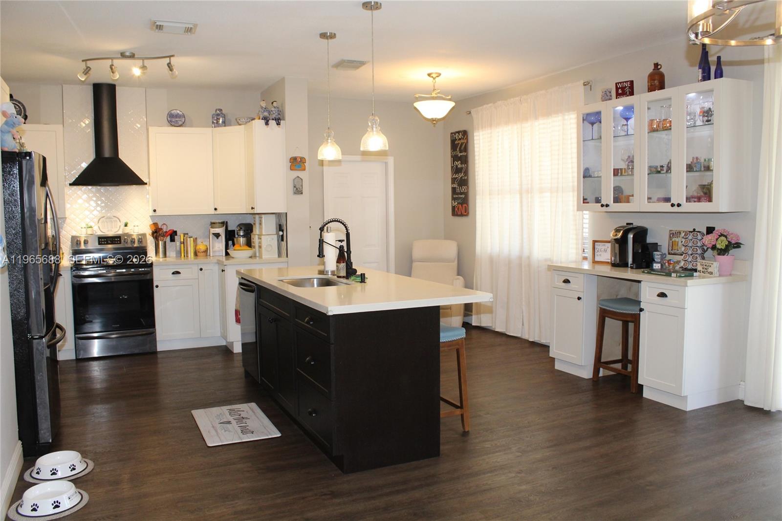 20135 Southwest 129th Avenue Miami, FL 33177 - Photo 42 of 54 a kitchen with stainless steel appliances a sink a stove a refrigerator and wooden floor