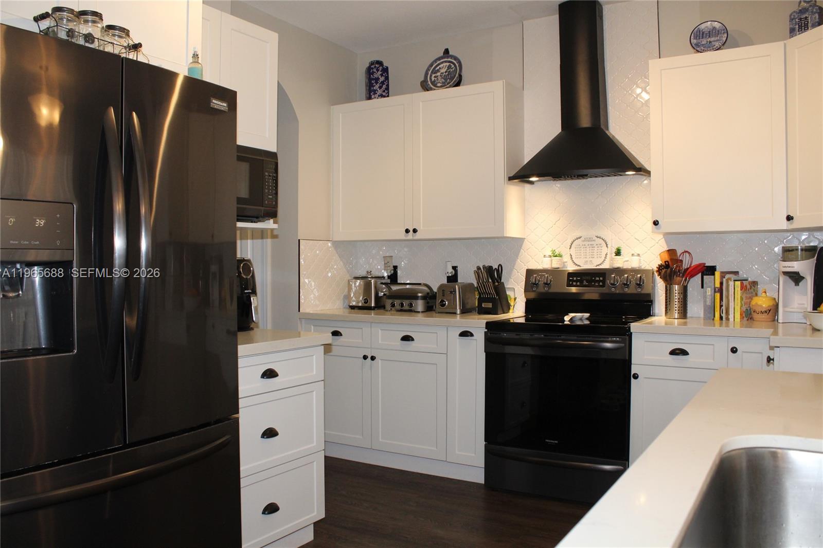 20135 Southwest 129th Avenue Miami, FL 33177 - Photo 43 of 54 a kitchen with a refrigerator and white cabinets
