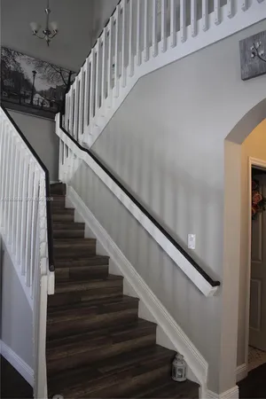 a view of a hallway with furniture and wooden floor
