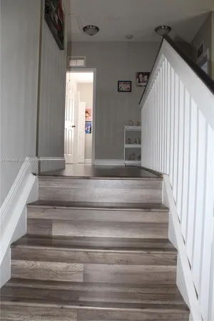 a living room with a bed a flat screen tv and dresser