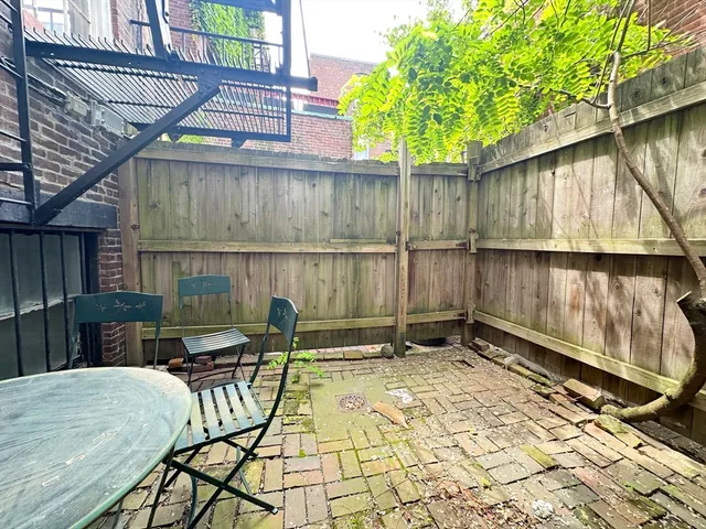 a backyard of a house with table and chairs