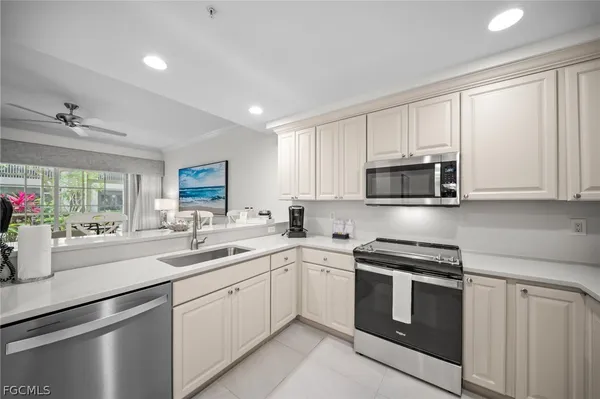 a kitchen with appliances a sink and cabinets