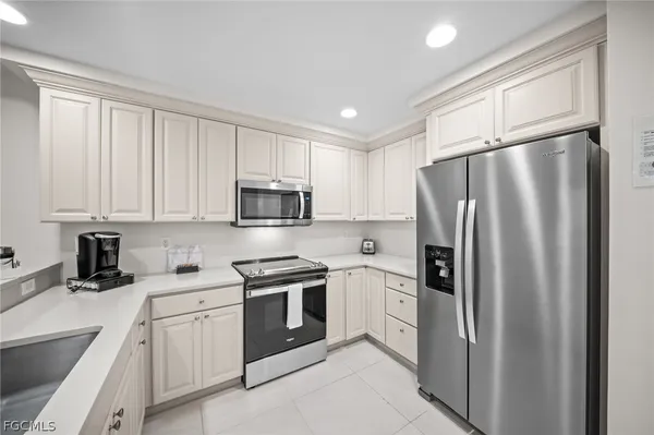 a kitchen with stainless steel appliances white cabinets and a refrigerator