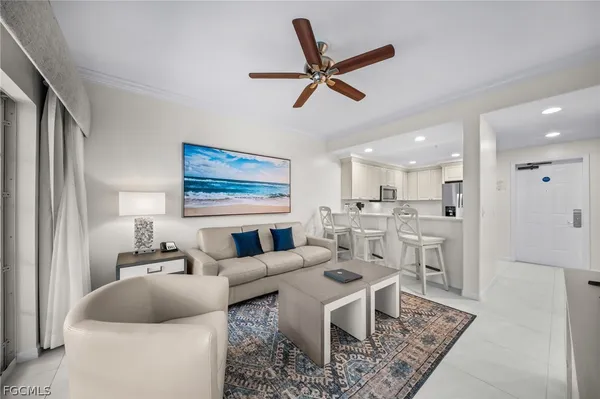 a living room with furniture and a view of kitchen