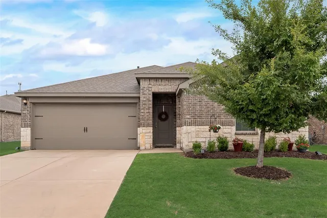 a front view of a house with a garden and garage