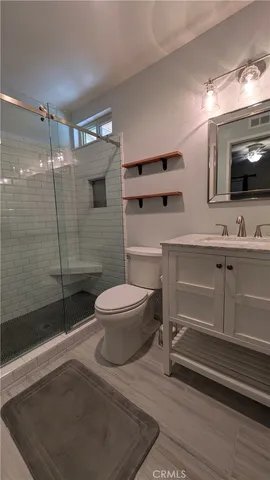 a bathroom with a sink a toilet a mirror and shower