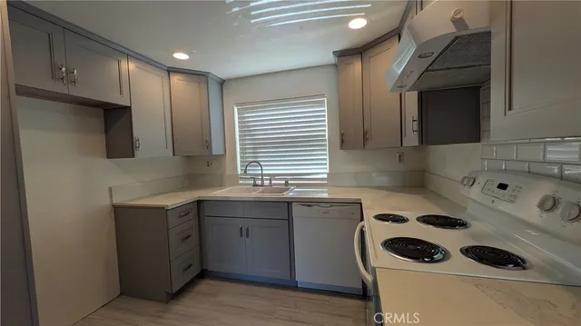 a kitchen with a sink a stove and cabinets