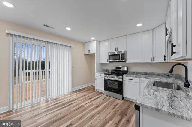 a kitchen with stainless steel appliances granite countertop a stove a sink and a refrigerator